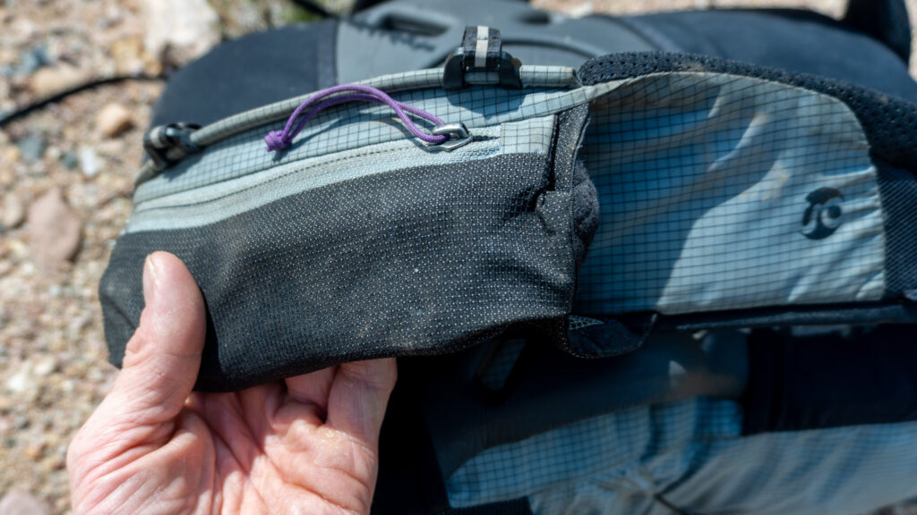 The front left pocket is only attached to the back pocket on one side, meaning you can more easily fit bulkier items, like my hard water bottle, in the back pocket, without sacrificing the volume of the front pocket